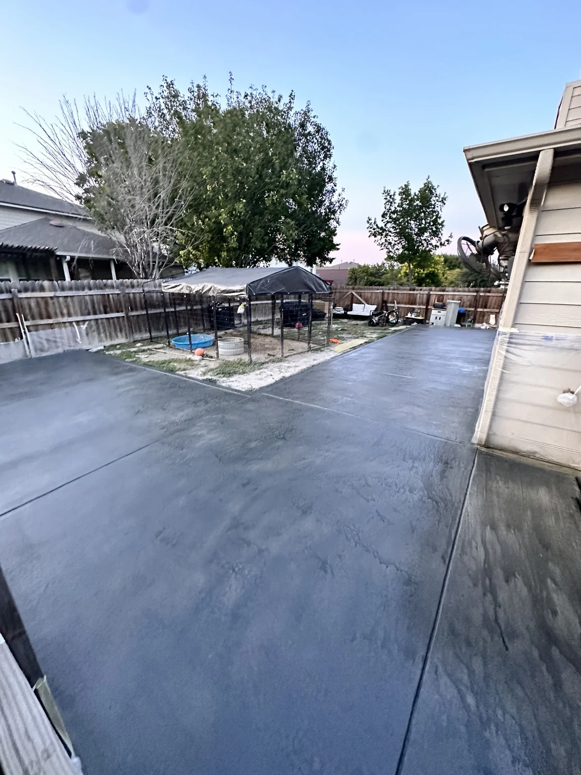 Large residential concrete area with intentionally varied topical stain.