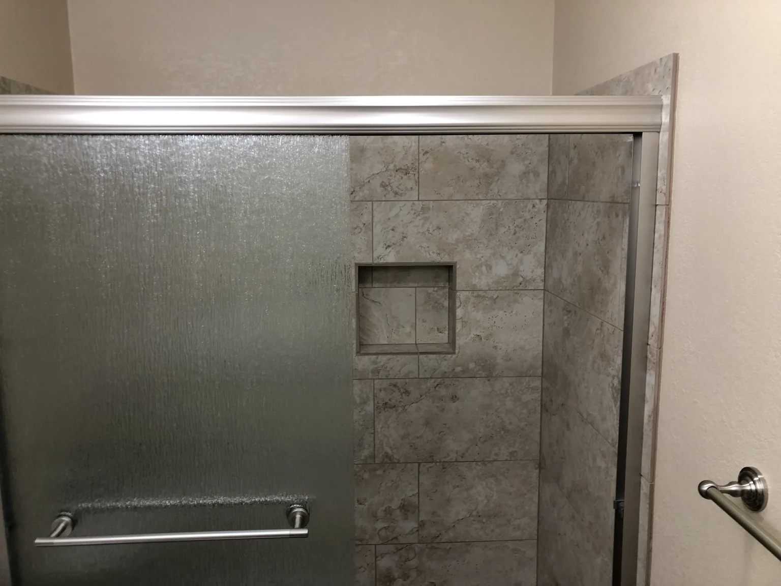 Tiled shower surround and built-in niche detail.