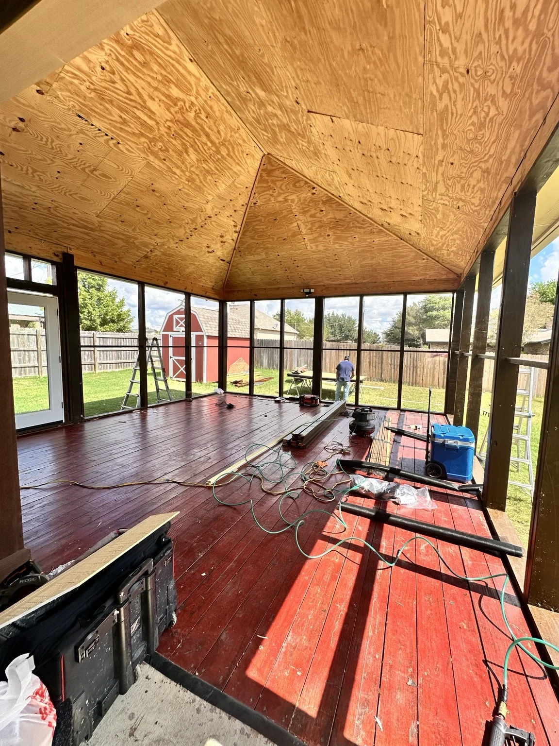 New roof framing and sheathing progressing over the retained deck.