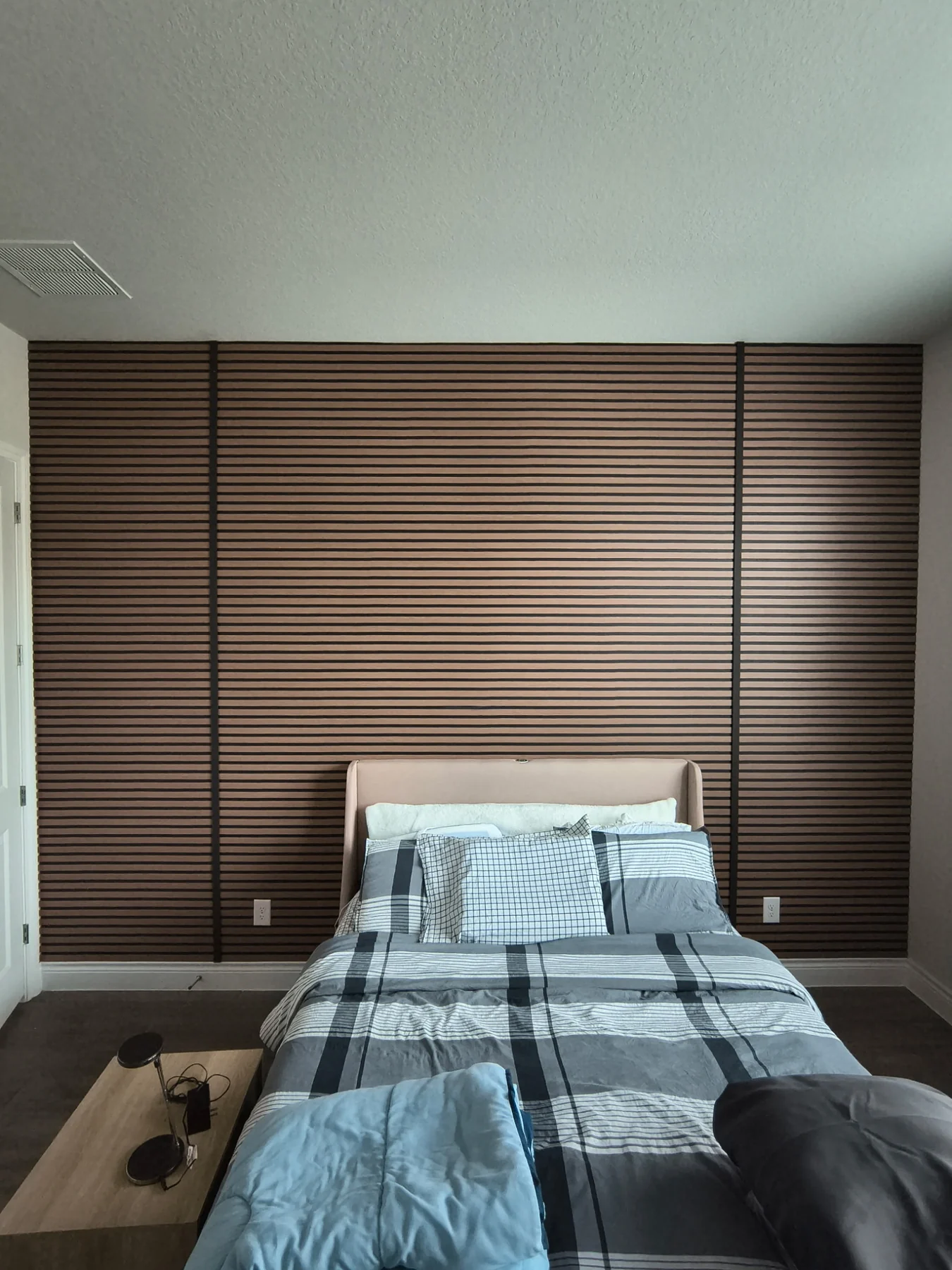 Full-wall architectural slat installation in a bedroom.